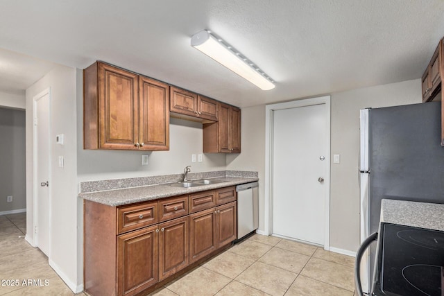 kitchen with a sink, light tile patterned floors, stainless steel appliances, and brown cabinets