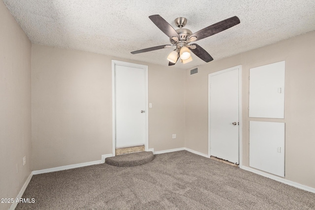 unfurnished bedroom featuring carpet flooring, a textured ceiling, visible vents, and baseboards