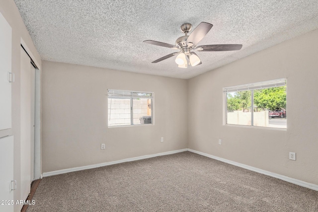 unfurnished bedroom featuring a textured ceiling, multiple windows, carpet, and a closet