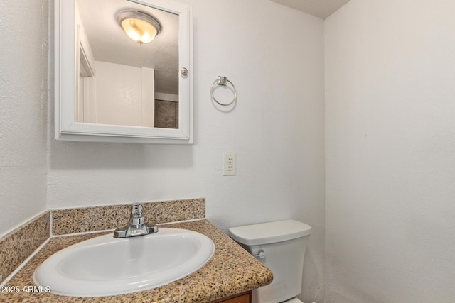 half bathroom featuring vanity and toilet