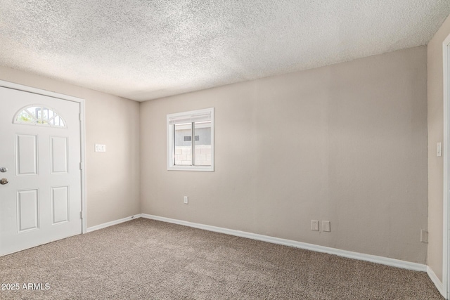 foyer entrance with carpet floors, a textured ceiling, and baseboards