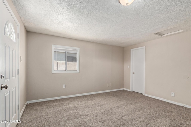 spare room with carpet floors, a textured ceiling, plenty of natural light, and baseboards