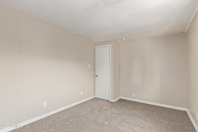 carpeted spare room with baseboards and a textured ceiling