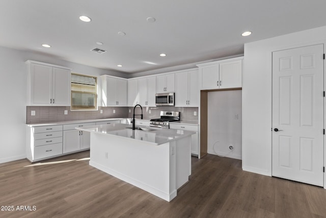 kitchen featuring sink, dark wood-type flooring, a kitchen island with sink, stainless steel appliances, and white cabinets