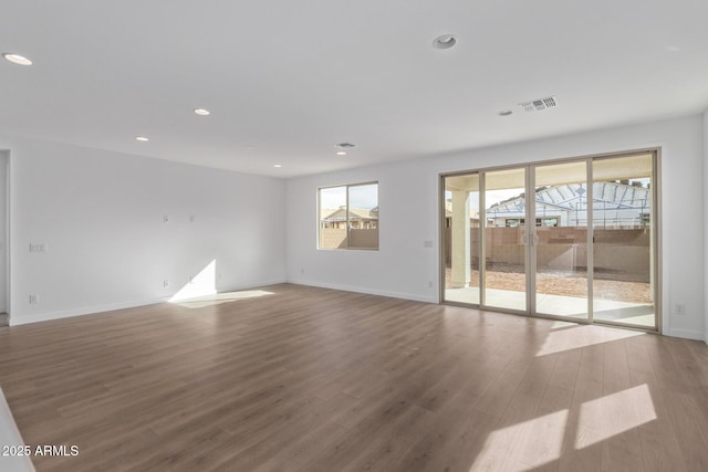 empty room featuring a healthy amount of sunlight and wood-type flooring