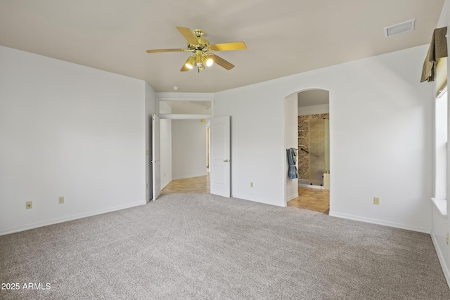 unfurnished bedroom featuring connected bathroom, light colored carpet, and ceiling fan