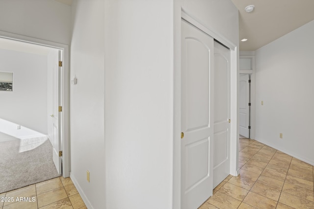 hallway with light colored carpet