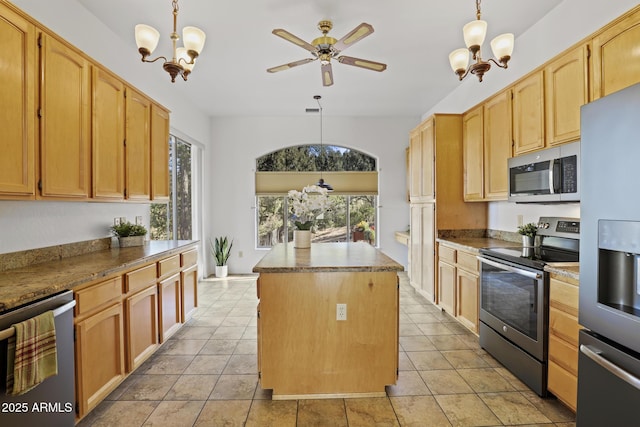 kitchen featuring decorative light fixtures, stainless steel appliances, a kitchen island, and light tile patterned flooring