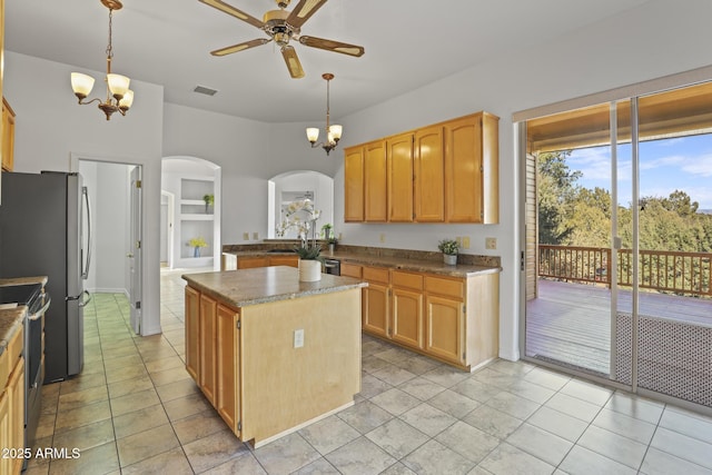 kitchen with built in features, stainless steel appliances, a kitchen island, and hanging light fixtures