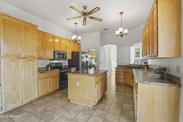 kitchen with sink, light tile patterned floors, appliances with stainless steel finishes, decorative light fixtures, and a kitchen island