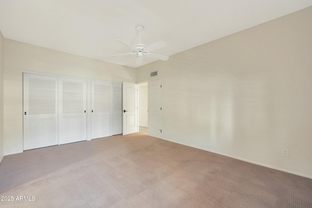 unfurnished bedroom featuring ceiling fan, two closets, and carpet