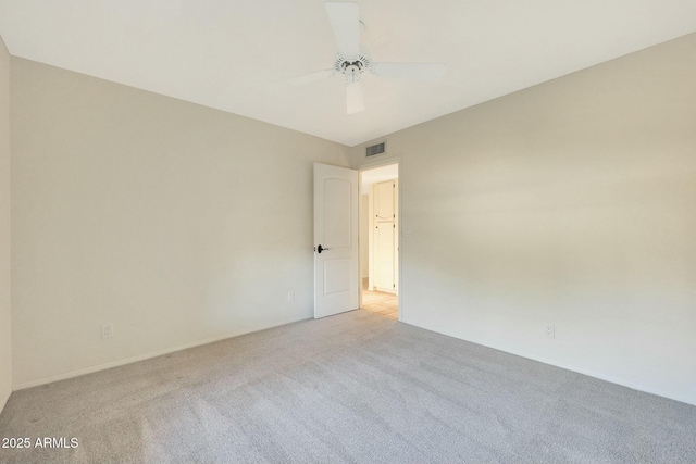 empty room with ceiling fan and light carpet