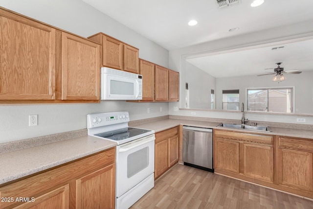 kitchen featuring visible vents, white appliances, light countertops, and a sink