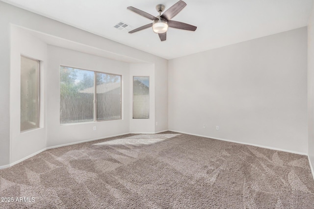 unfurnished room with visible vents, baseboards, carpet, and ceiling fan