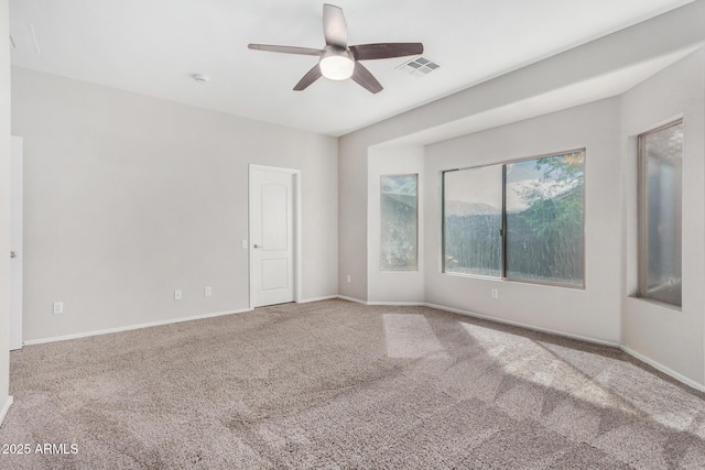 empty room featuring visible vents, carpet flooring, baseboards, and a ceiling fan