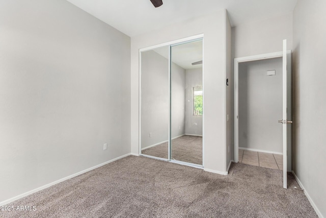 unfurnished bedroom featuring a closet, carpet floors, baseboards, and ceiling fan