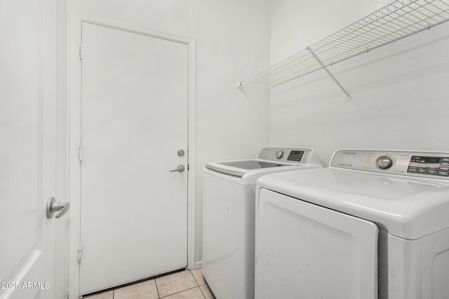 washroom with laundry area, light tile patterned floors, and independent washer and dryer