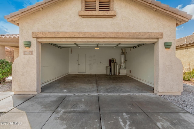 garage with concrete driveway and strapped water heater