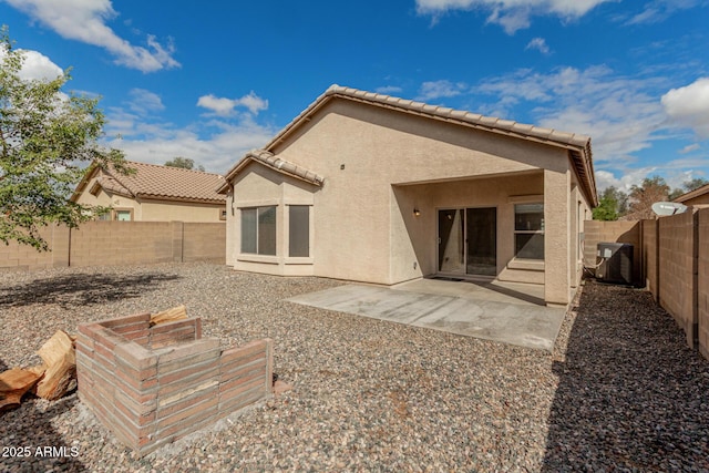 back of property featuring stucco siding, a tiled roof, and a fenced backyard