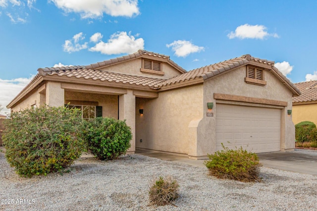 view of front of house featuring stucco siding, an attached garage, and a tile roof