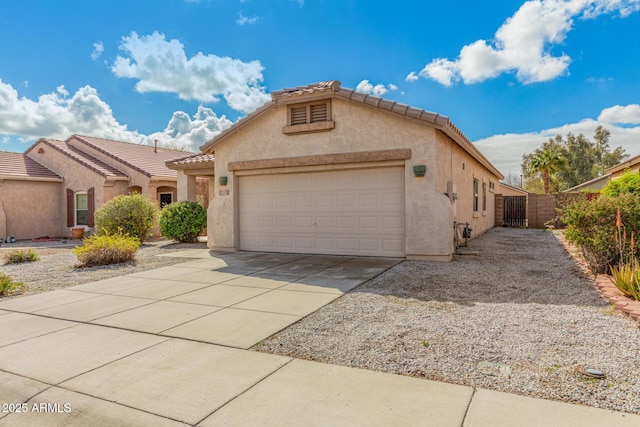 mediterranean / spanish-style house featuring a tile roof, an attached garage, driveway, and stucco siding