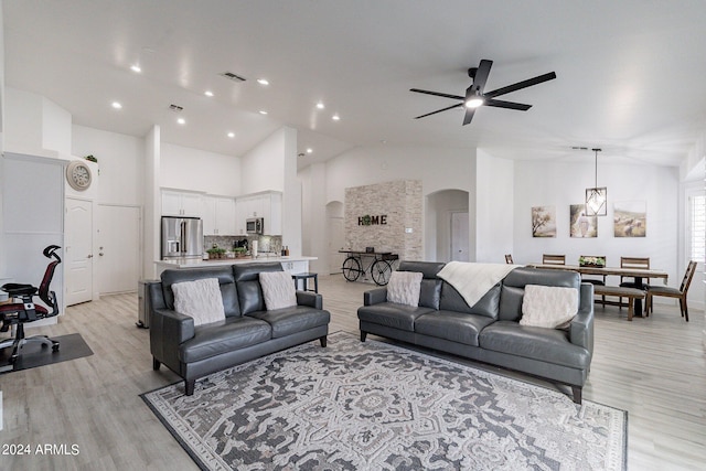 living room featuring high vaulted ceiling, ceiling fan, and light hardwood / wood-style flooring