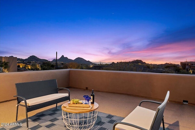 patio terrace at dusk with a balcony and a mountain view