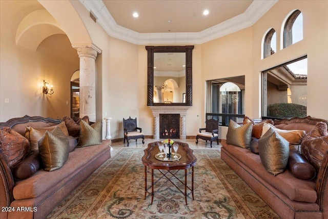 living room featuring ornamental molding, a high ceiling, and ornate columns