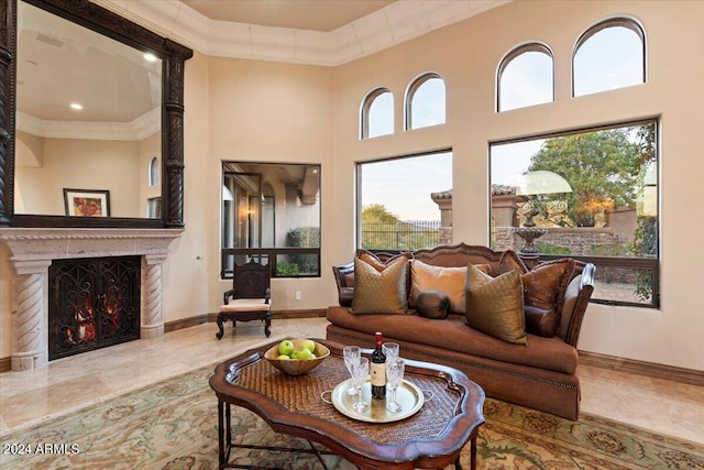 living room featuring crown molding, a towering ceiling, and a premium fireplace