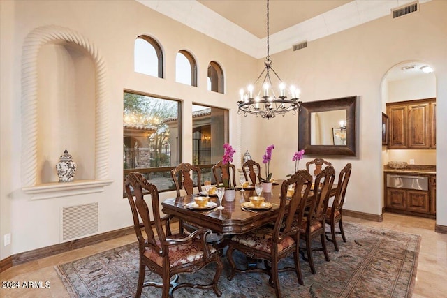 dining room with an inviting chandelier and a towering ceiling