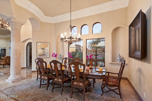 dining space with a notable chandelier, ornamental molding, a high ceiling, and ornate columns