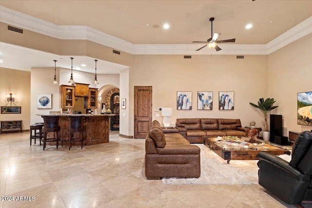 living room featuring crown molding, a towering ceiling, and ceiling fan