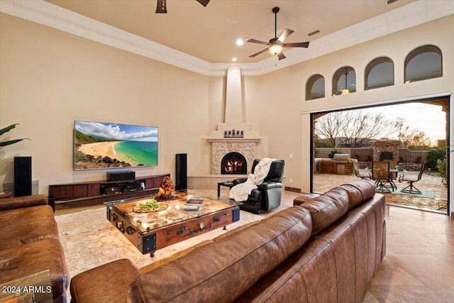 tiled living room featuring crown molding, a towering ceiling, and ceiling fan