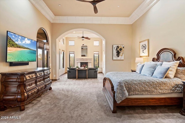 carpeted bedroom with crown molding, a towering ceiling, and ceiling fan