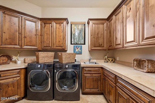 washroom featuring cabinets, sink, and washing machine and dryer