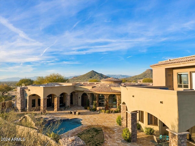 back of property featuring a mountain view and a patio