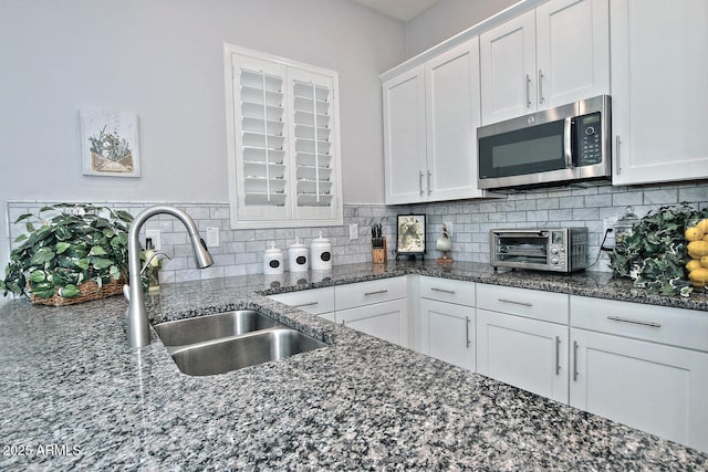 895 E Clovefield St, Gilbert, AZ 85298 - kitchen featuring stainless steel microwave, white cabinets, a sink, and backsplash