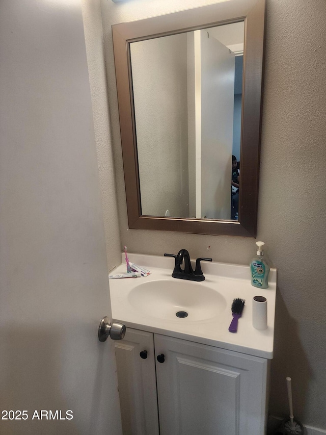 bathroom with vanity and a textured wall