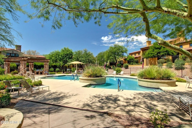 community pool with a pergola, fence, and a patio area