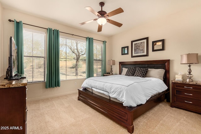bedroom with light colored carpet, baseboards, and a ceiling fan