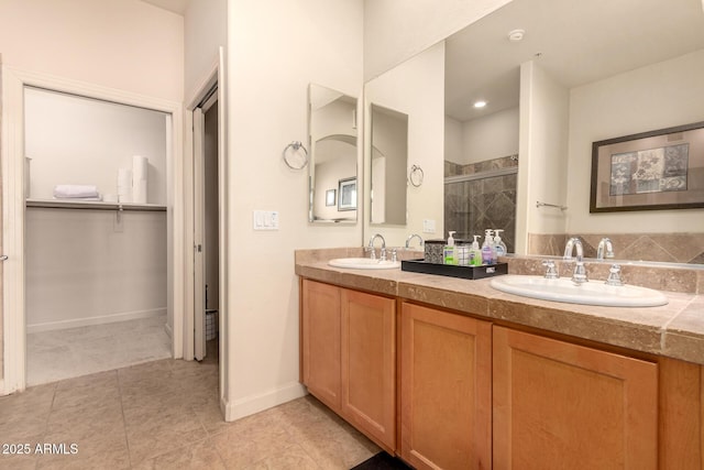 bathroom featuring a stall shower, double vanity, tile patterned flooring, and baseboards