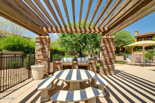 view of patio / terrace featuring an outdoor kitchen, fence, a pergola, and grilling area