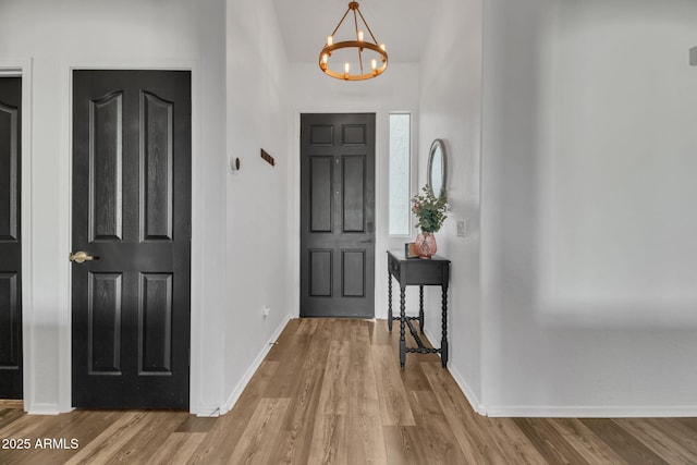 foyer featuring an inviting chandelier and light hardwood / wood-style flooring