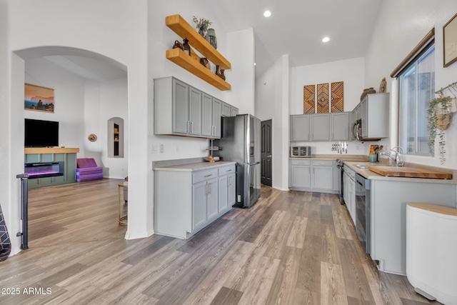 kitchen featuring stainless steel appliances, gray cabinetry, and light hardwood / wood-style floors