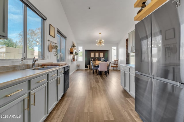 kitchen featuring hanging light fixtures, sink, gray cabinetry, and black appliances