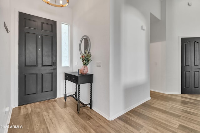 foyer entrance featuring light hardwood / wood-style flooring and a notable chandelier