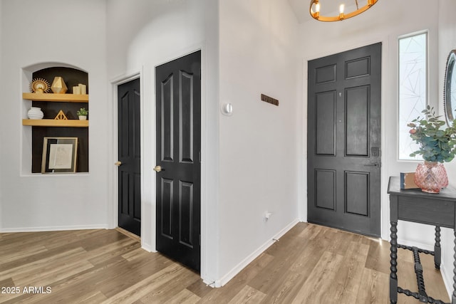 foyer entrance with a notable chandelier and light hardwood / wood-style floors