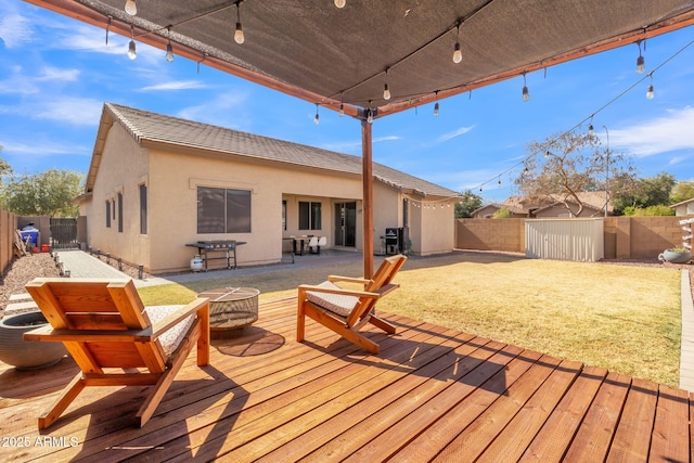 wooden terrace featuring a grill, a shed, and an outdoor fire pit