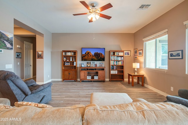 living room featuring light hardwood / wood-style floors and ceiling fan