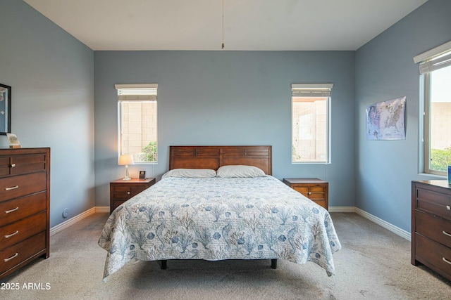 bedroom featuring multiple windows and light carpet